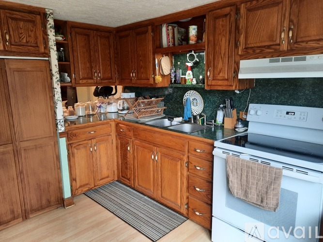 A kitchen with wooden cabinets and a white oven.