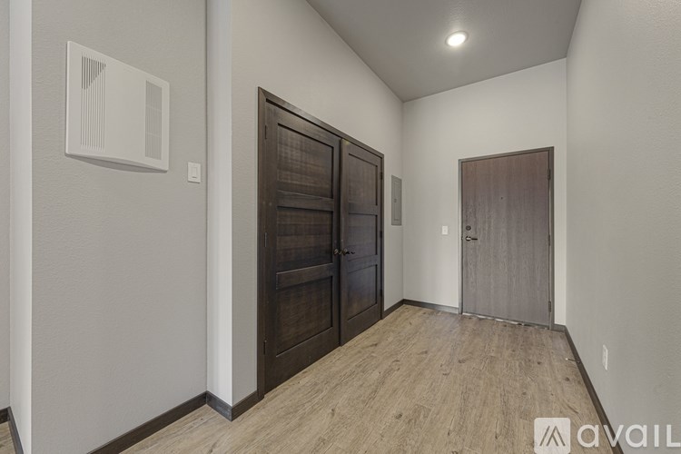 A room with two doors and a wooden floor.