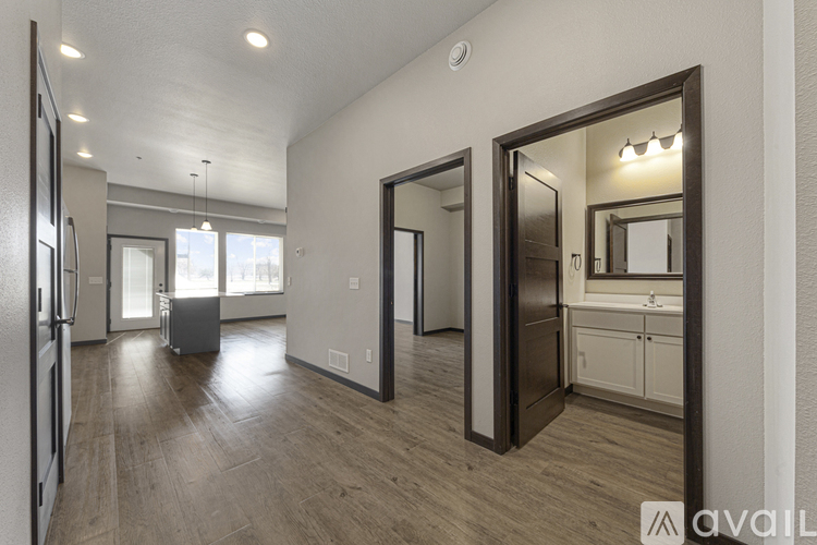 A spacious kitchen with a refrigerator, sink, and cabinets is visible through a large mirror.
