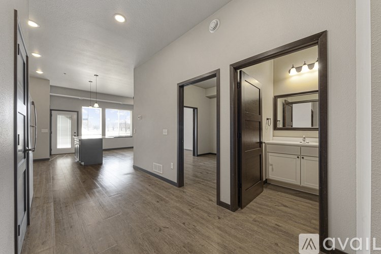 A spacious kitchen with a refrigerator, sink, and cabinets is visible through a large mirror.