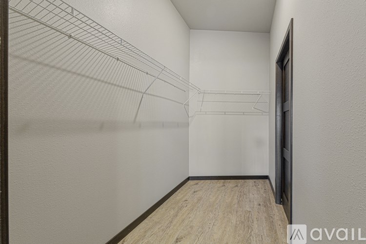 A long hallway with a wooden floor and white walls.