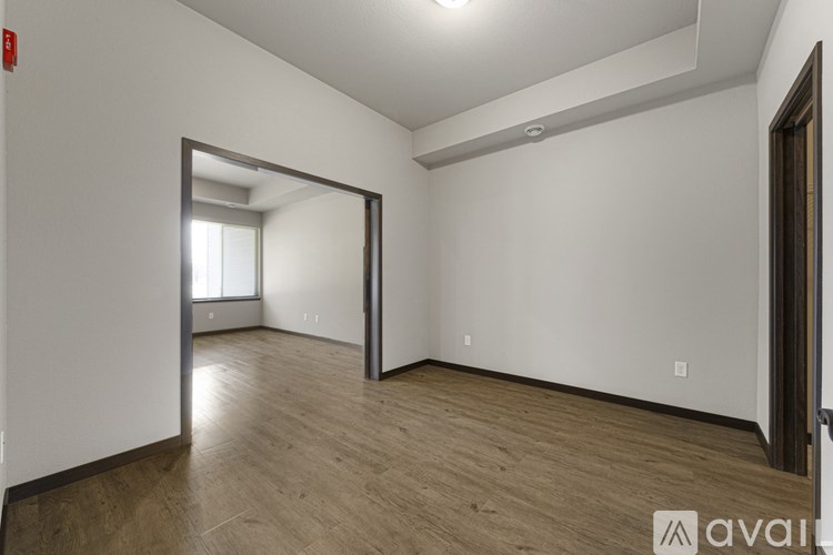 A room with wooden flooring and a large mirror on the wall.