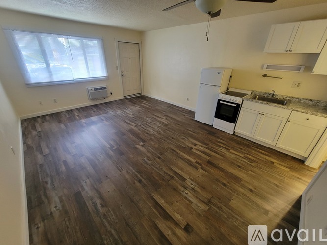 A kitchen with wooden floors and white appliances.