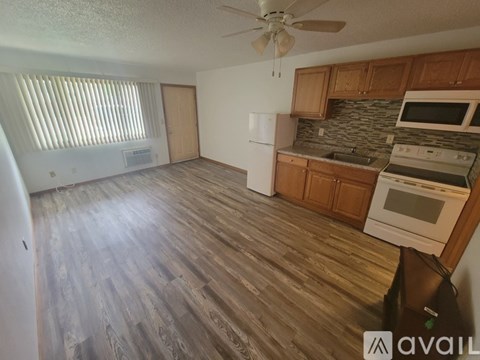 A kitchen with wooden floors and white appliances.