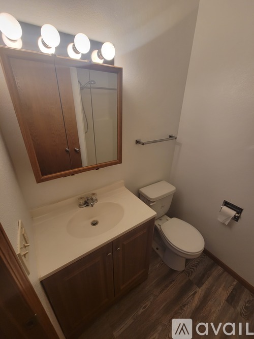 A white shower stall with a silver grab bar.