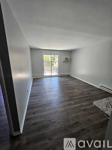 A room with wooden floors and a door leading outside.