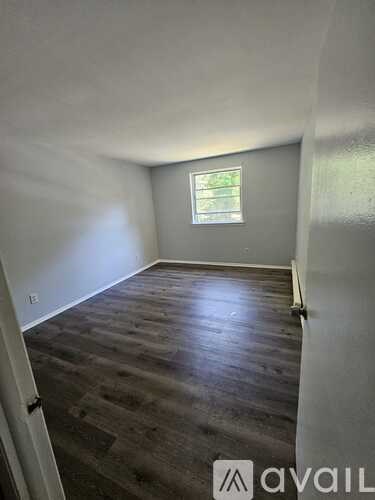 A room with wooden flooring and a window.