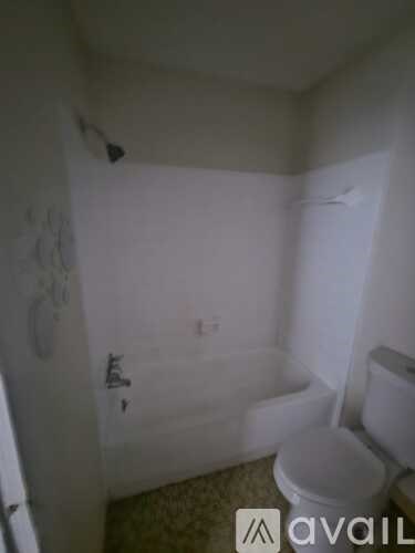 A small bathroom with a toilet and a shower.