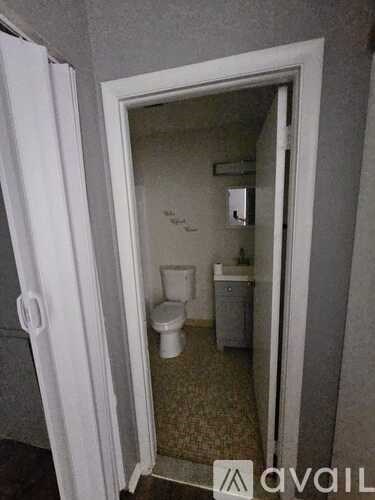 A bathroom with a toilet and sink is visible through a doorway.
