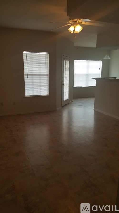 A room with a ceiling fan and two windows.