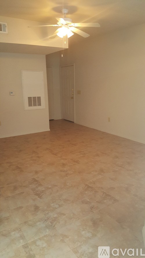 A room with a ceiling fan and tile flooring.
