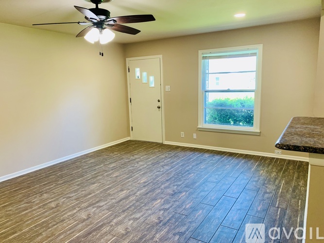 A room with a ceiling fan and a window.