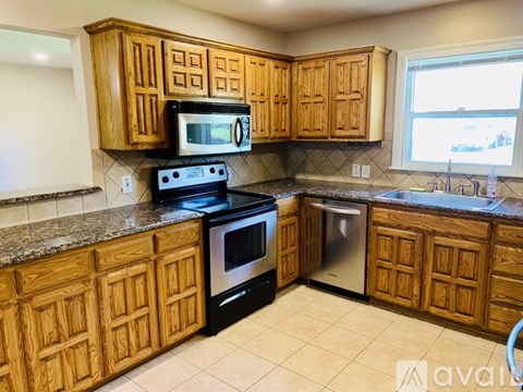 A kitchen with wooden cabinets and a black stove top oven.