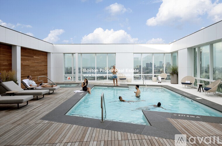 A group of people are enjoying a swim in a pool at Boston Proper Real Estate.