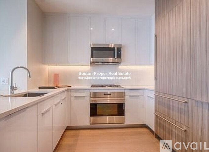 A kitchen with white cabinets and a stainless steel oven.