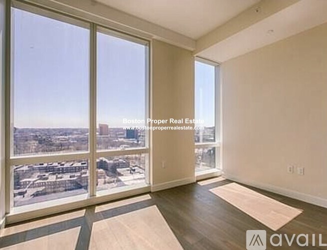 A room with a view of the city through large windows.