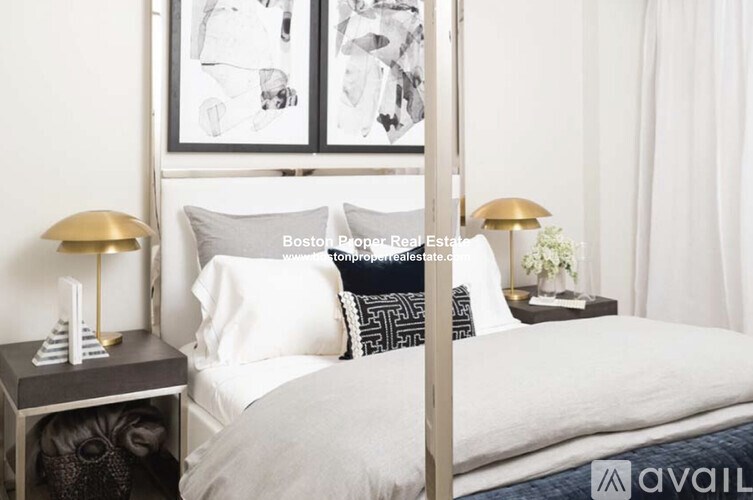 A bedroom with a bed, nightstand, and lamp.