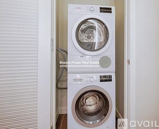 A white washing machine is in a small room.