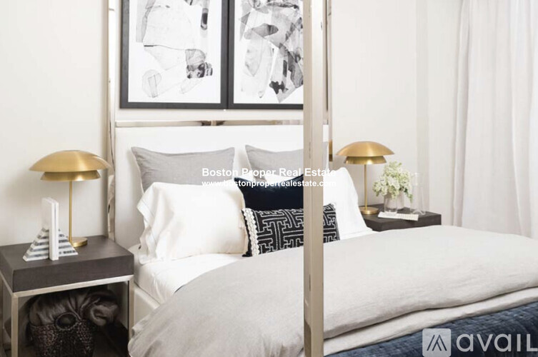A bedroom with a bed, nightstand, and lamp.