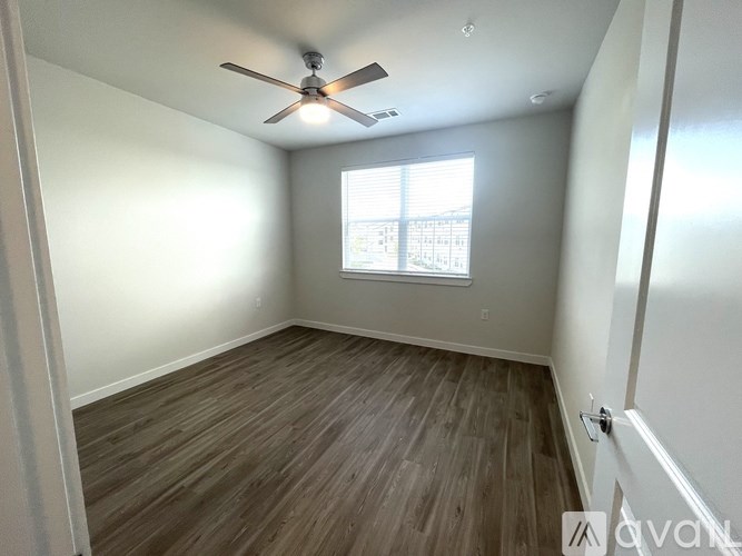 A room with a ceiling fan and a window.