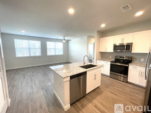 A kitchen with a granite countertop and stainless steel appliances.