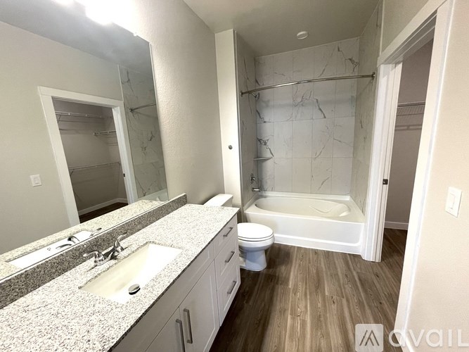 A bathroom with a marble countertop and a walk-in shower.