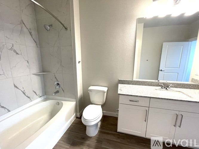 A white toilet sits in a bathroom next to a bathtub.