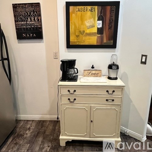 A white dresser with a coffee maker on top of it.