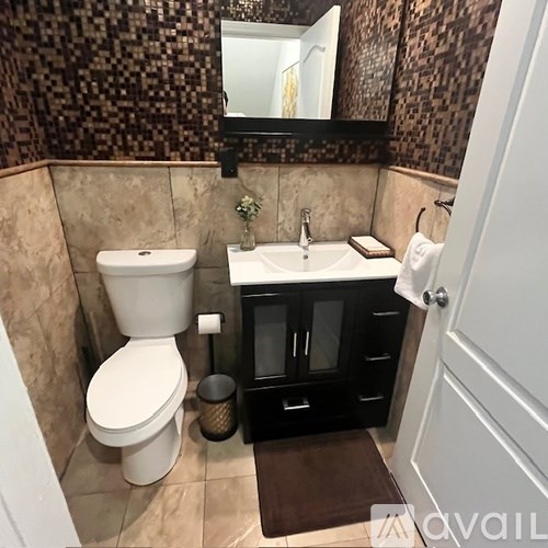 A bathroom with a toilet, sink, and mirror.