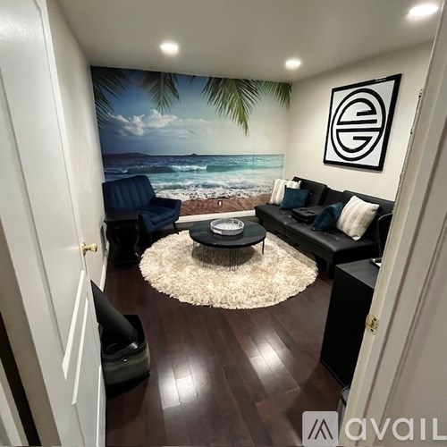 A living room with a beach mural on the wall.