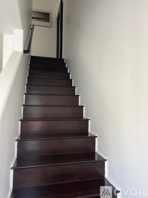 A staircase with a dark wood finish and white walls.