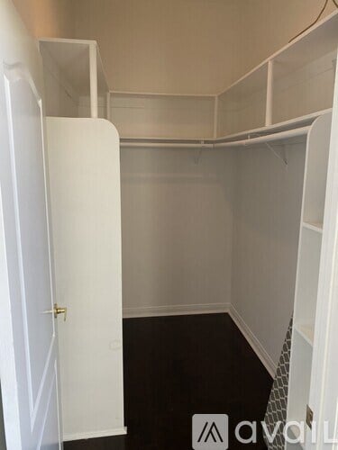 A white closet with a door open and a shelf on the right.
