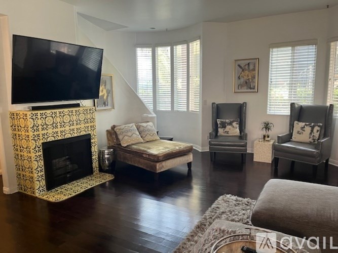 A living room with a fireplace and a television.