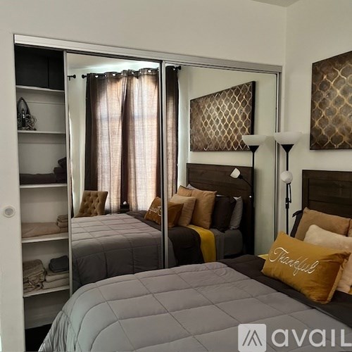 A bedroom with two beds and a mirror on the wall.