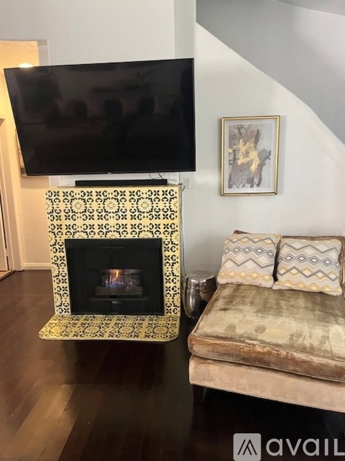 A black television is mounted above a fireplace in a living room.