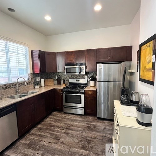 A kitchen with brown cabinets and a stainless steel refrigerator.