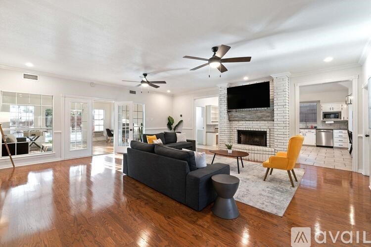 A living room with a grey couch, a yellow chair, and a fireplace.