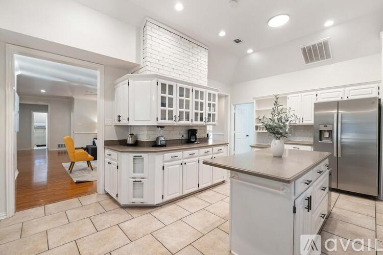 A kitchen with white cabinets and a marble countertop.