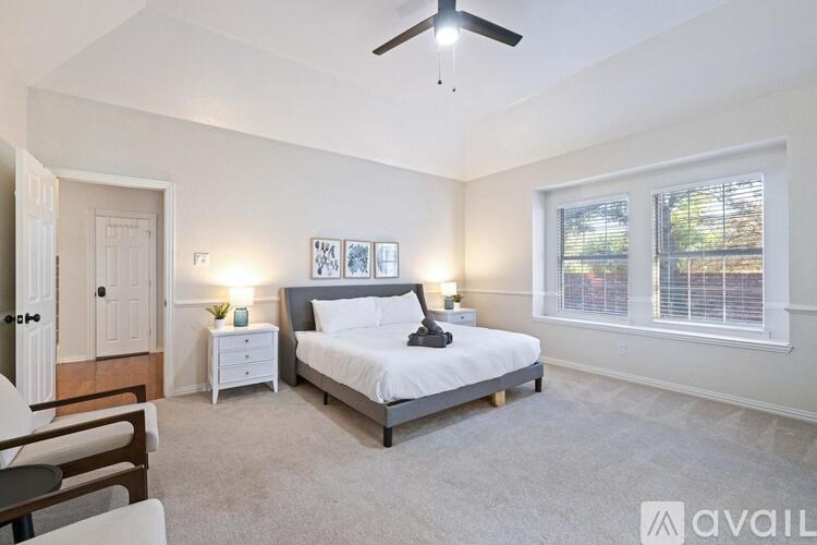 A bedroom with a bed, nightstand, and a ceiling fan.
