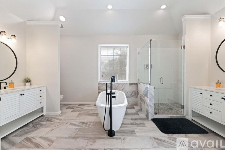 A bathroom with a white tub and a window.
