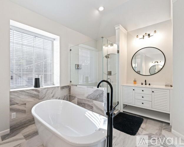 A modern bathroom with a large tub and a walk-in shower.