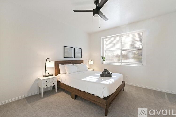 A bedroom with a bed, nightstand, and a ceiling fan.