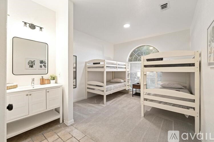 A bathroom with a mirror, sink, and bunk beds.