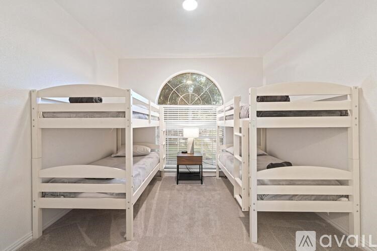 A room with two bunk beds and a table in the middle.