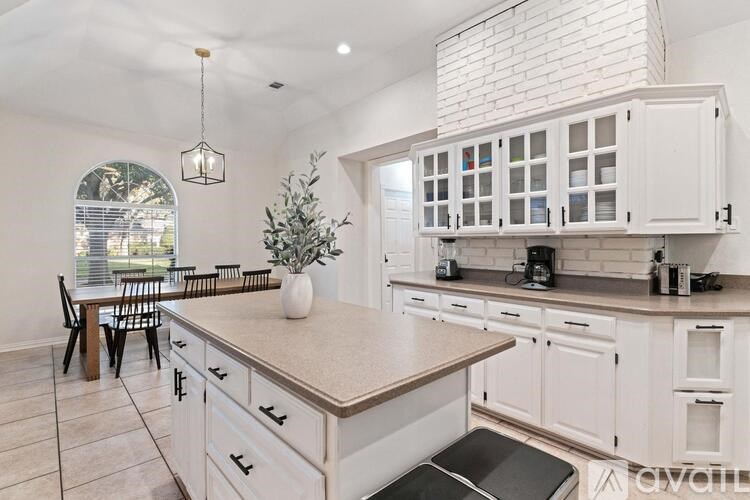 A kitchen with white cabinets and a large island.