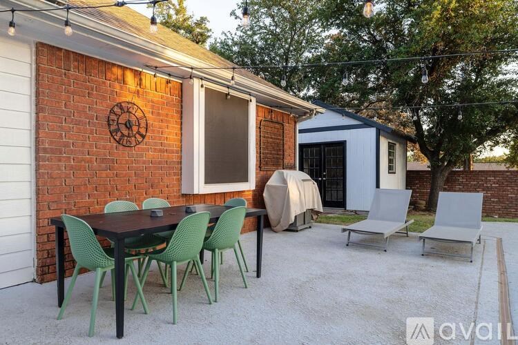 A patio with a table and chairs is set up outside a house.