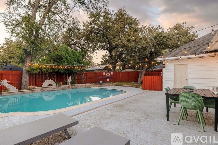 A backyard with a pool and a table set up for an outdoor gathering.