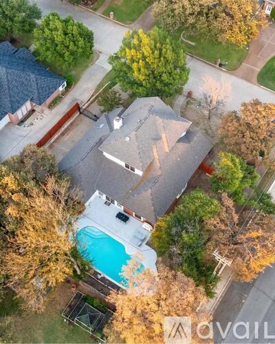 A house with a pool surrounded by trees.