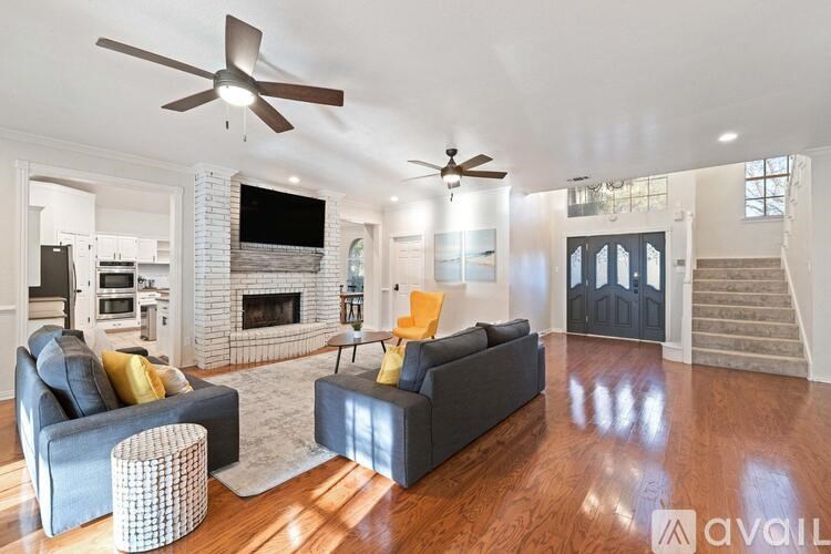 A living room with a fireplace and a grey couch.