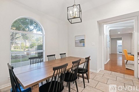 A dining room with a wooden table and chairs.